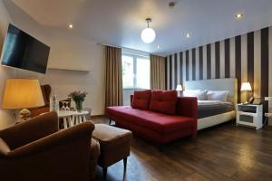 a hotel room with a bed and a red couch at VITALHOTEL Schulenberg in Schulenberg im Oberharz