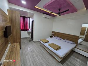 a bedroom with a bed with a purple ceiling at Hotel Shreejay Lodging in Mahād