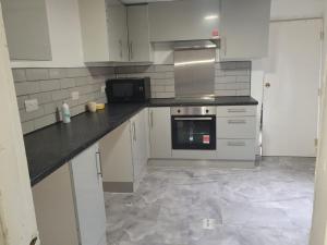 a kitchen with white cabinets and black counter tops at City view place, City Centre in Chesterton