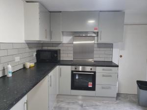 a kitchen with white cabinets and a stove top oven at City view place, City Centre in Chesterton