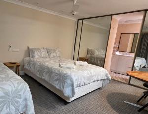 a bedroom with a bed and a large mirror at Sisleys Motel in Lismore +10 photos