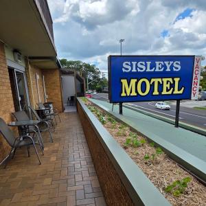 a sign for aissleys motel outside of a building at Sisleys Motel in Lismore