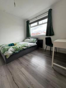 a bedroom with a bed and a window and a desk at Victoria Park in Bristol