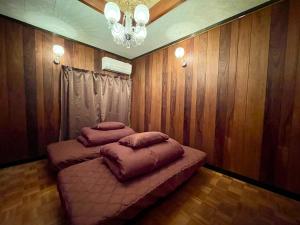 ein Zimmer mit einem Bett und zwei Kissen darauf in der Unterkunft Goodies Ella Villa & Guesthouse in Shimonoseki