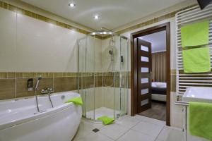 a bathroom with a tub and a shower and a sink at VITALHOTEL Schulenberg in Schulenberg im Oberharz +49 photos