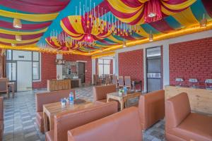 a restaurant with a colorful ceiling and tables and chairs at Treebo Holiday Hill in Dharmsāla