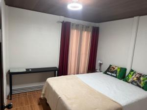 a bedroom with a bed and a table in it at Ticary Nature Homes in Guápiles