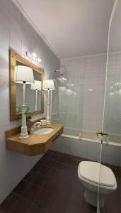 a bathroom with a toilet and a sink and a mirror at Casona en pleno Centro in Tandil +72 photos