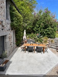 a wooden table and chairs in a garden at Chez Natacha et Adrien in Regnéville-sur-Mer