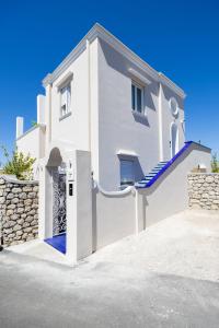 a white house with a gate and a stone wall at Palazzo Sant'Elena in Anacapri