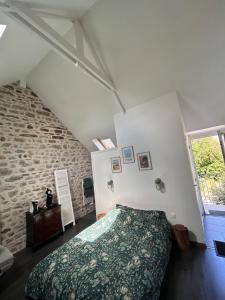a bedroom with a bed and a stone wall at Chez Natacha et Adrien in Regnéville-sur-Mer