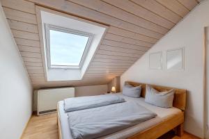 a bedroom with a large bed with a window at Weingut Geiger in Meersburg