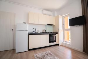 a kitchen with white cabinets and a white refrigerator at Real Resort in Ploieşti