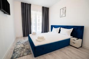 a bedroom with a blue bed and a window at Real Resort in Ploieşti