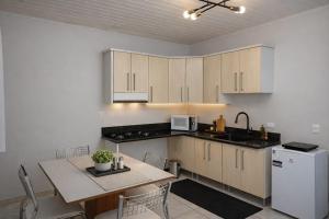 a kitchen with a table and a white refrigerator at Flat Completo - Cozinha - Lavadora - Climatizado in Erval dʼOeste