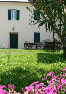 a building with benches and pink flowers in a yard at Monica appartamenti in San Vincenzo