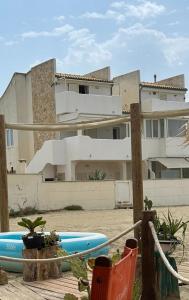 a house with a blue surfboard in front of it at Fiorucci Apartments - Veronica's House Fiumicino in Focene