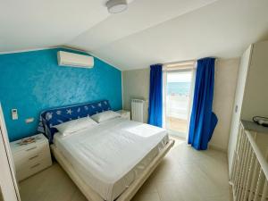 a bedroom with a bed with blue walls and a window at Fiorucci Apartments - Veronica's House Fiumicino in Focene