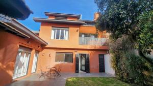 an orange house with chairs and tables in front of it at Casona en pleno Centro in Tandil