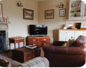 a living room with a couch and a tv at Clock View - Haworth in Haworth