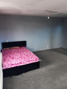 a bedroom with a pink bed in a room at OGb in Bolton