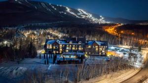 an aerial view of a resort in the snow at night at Modern Condo with Pool - Le Rendez-Vous in Beaupré