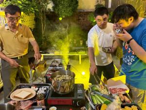 a group of men standing around a grill with food at 朗香洋房 台南安平民宿2-12人包棟 in Tainan +92 photos