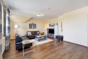 a living room with a couch and a table at Pure Relaxation in Heiligenhafen