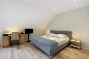 a bedroom with a bed and a desk at Pure Relaxation in Heiligenhafen