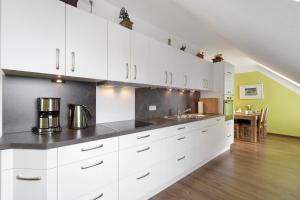 a large kitchen with white cabinets and a table at Pure Relaxation in Heiligenhafen