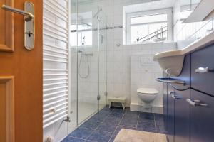 a bathroom with a shower and a toilet and a sink at Pure Relaxation in Heiligenhafen +27 photos