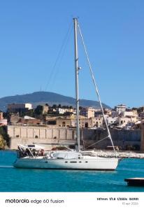 a sailboat in the water in front of a city at Gloria Sailing in Porticello