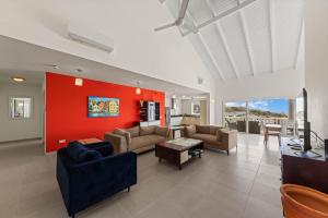 a living room with couches and a red wall at Blue Horizon Penthouse in Dorp Sint Michiel