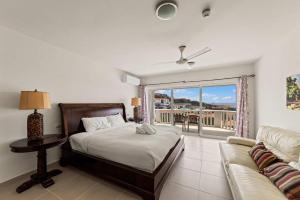 a bedroom with a bed and a couch and a window at Blue Horizon Penthouse in Dorp Sint Michiel