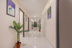 a hallway with plants and pictures on the walls at Treebo GT Meridian, T-Nagar in Chennai