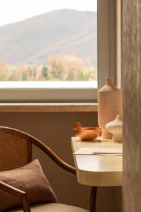 a table with a vase on it next to a window at Hotel Al Sant'Andrea in Sarzana