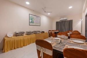 a dining room with tables and chairs and a table set up at Treebo GT Meridian, T-Nagar in Chennai