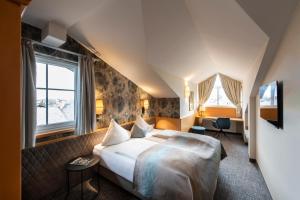 a hotel room with a large bed and windows at Hotel Königgut in Wals
