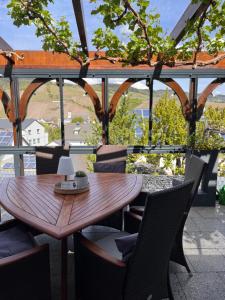 a wooden table and chairs on a balcony at Weingut Zenz-Pohl in Kinheim