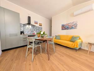 a living room with a table and a yellow couch at Borgo Mare in Piombino