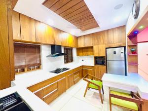 a kitchen with wooden cabinets and a white counter top at THE iVORY VILLA in Kottayam +13 photos