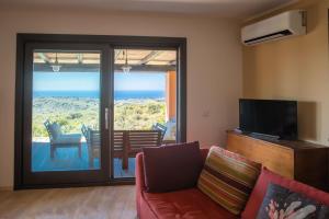 a living room with a couch and a sliding glass door at Fantastica Villa con piscina e vista mare in Alghero