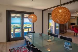 a dining room with a glass table and chairs at Fantastica Villa con piscina e vista mare in Alghero
