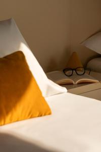 a pair of glasses sitting on a book on a bed at Hotel Al Sant'Andrea in Sarzana +37 photos