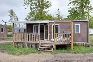 a tiny house with a porch and a deck at Mobilehome riviera avec terrasse 48 in Saint-Gervais