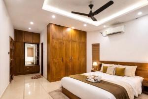 a bedroom with a large bed with a ceiling fan at THE iVORY VILLA in Kottayam