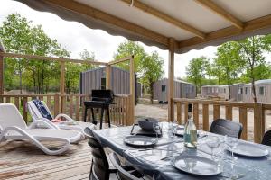 a patio with a table and chairs on a deck at Mobilehome riviera avec terrasse 48 in Saint-Gervais