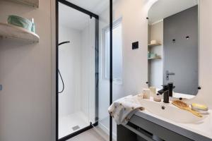 a bathroom with a sink and a mirror at Mobilehome riviera avec terrasse 48 in Saint-Gervais