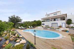 a house with a swimming pool on a wooden deck at Encanto dos Montes in Alvor
