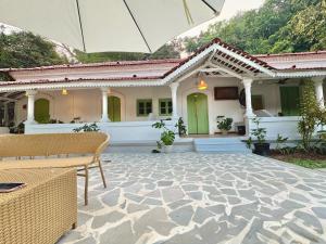 a house with a stone patio with an umbrella at cali stays in Chapora
